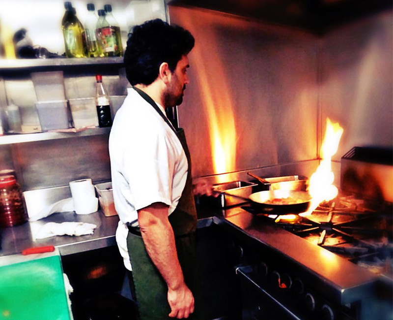 Chef Osman Yilmaz cooking with a flaming pan